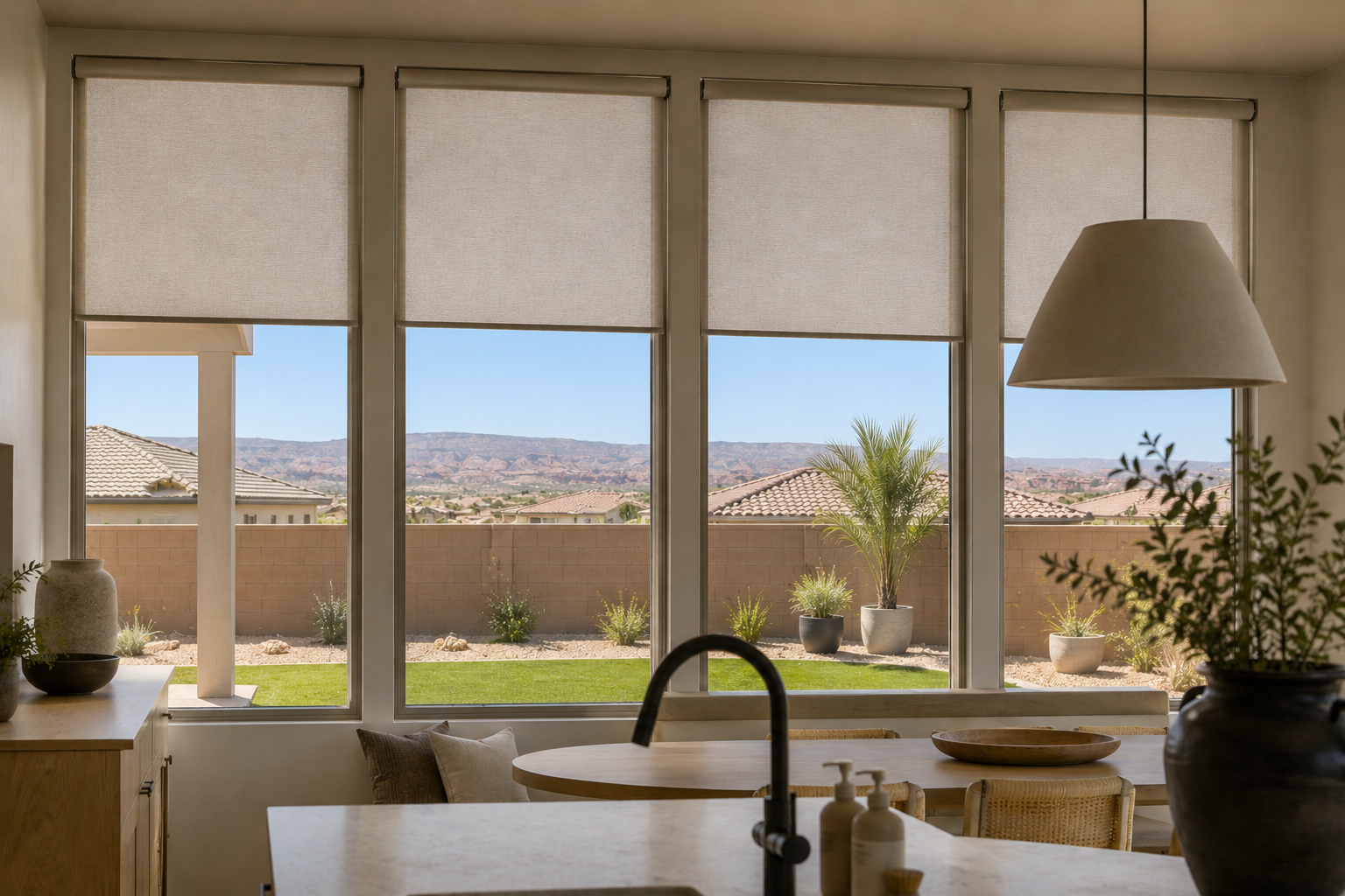 Roller shades lowered across a kitchen window wall framing a Southern Utah desert view.