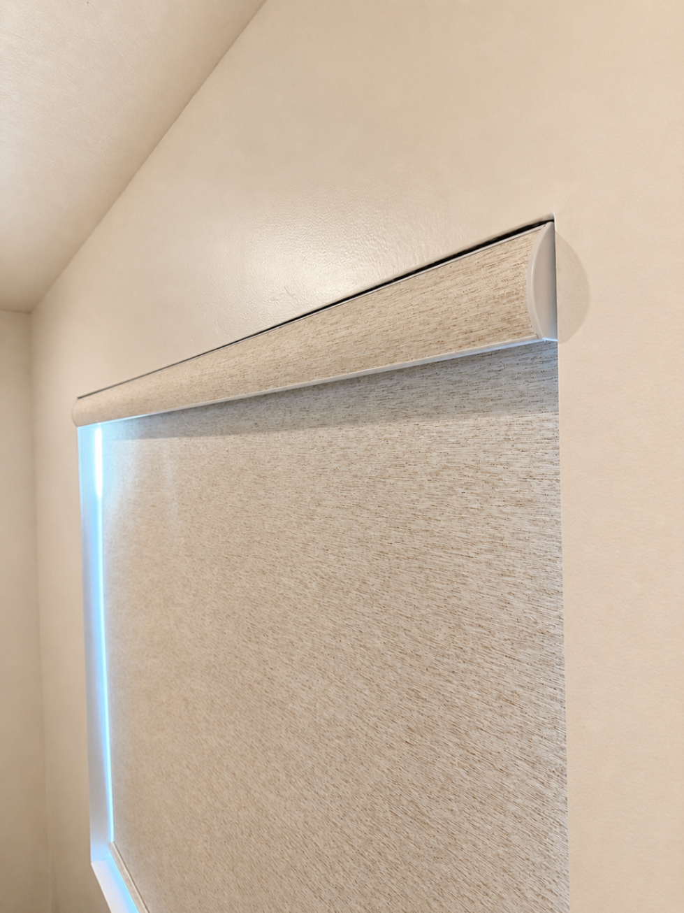 Roller shade rolled up over a St. George backyard, showing the red-rock landscape beyond.